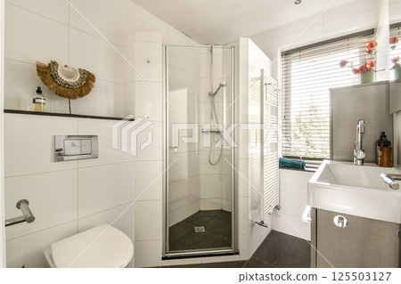 A sleek and contemporary bathroom featuring a walk-in shower, stylish fixtures, and elegant storage solutions, all designed for convenience and aesthetics. 125503127
