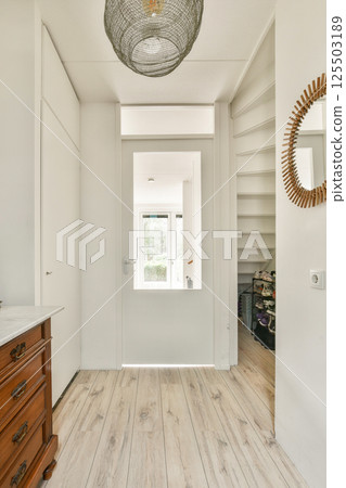 This image showcases a bright and airy entryway with elegant decor elements, including a unique light fixture and stylish mirror, enhancing the modern aesthetic. This image showcases a bright and airy entryway with elegant decor elements, including a unique light fixture and stylish mirror, enhancing the modern aesthetic. 125503189