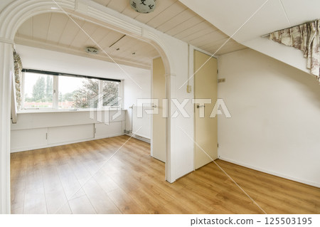 A light-filled, minimalist room showcasing clean lines and simple decor. The large window enhances the airy atmosphere, emphasizing modern living. A light-filled, minimalist room showcasing clean lines and simple decor. The large window enhances the airy atmosphere, emphasizing modern living. 125503195