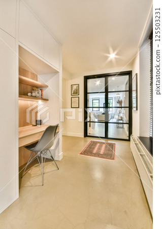 A beautifully designed modern interior featuring a minimalist study space, elegant lighting, and sleek furnishings that exude sophistication and comfort. 125503231