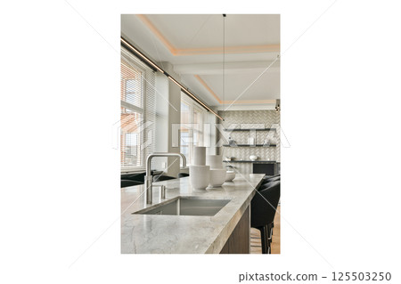 Sleek and stylish kitchen featuring a marble countertop, elegant lighting, and contemporary decor elements enhancing the overall aesthetic. 125503250