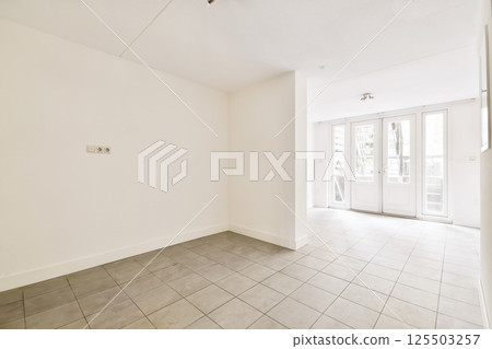an empty living room with tile flooring and sliding glass door leading to the patio area in this apartment building an empty living room with tile flooring and sliding glass door leading to the patio area in this apartment building 125503257