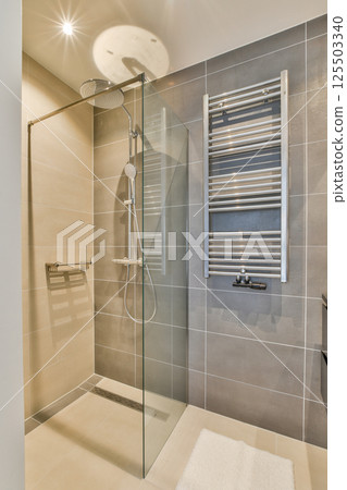 A sleek and modern bathroom featuring a glass shower enclosure, stylish wall tiles, and contemporary fixtures, creating a serene and inviting atmosphere. A sleek and modern bathroom featuring a glass shower enclosure, stylish wall tiles, and contemporary fixtures, creating a serene and inviting atmosphere. 125503340