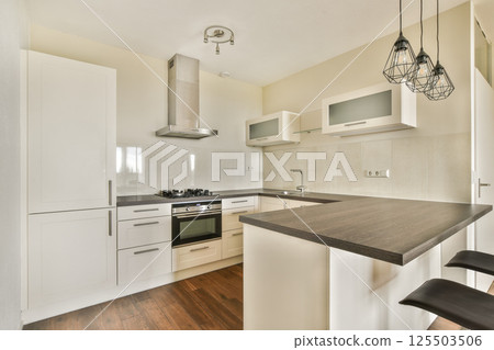 A sleek and stylish modern kitchen featuring contemporary cabinetry, a central island, and sophisticated appliances, ideal for cooking and entertaining. A sleek and stylish modern kitchen featuring contemporary cabinetry, a central island, and sophisticated appliances, ideal for cooking and entertaining. 125503506