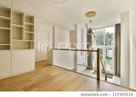 Spacious interior featuring sleek lines, ample natural light, and minimalist decor. A perfect blend of contemporary style and comfort in a living space. Spacious interior featuring sleek lines, ample natural light, and minimalist decor. A perfect blend of contemporary style and comfort in a living space. 125503519