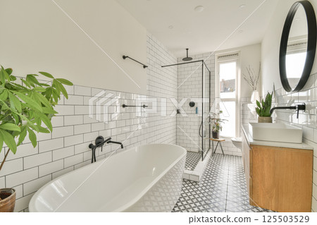 A contemporary bathroom featuring a stylish tub, elegant fixtures, and a touch of greenery that enhances the serene ambiance. A contemporary bathroom featuring a stylish tub, elegant fixtures, and a touch of greenery that enhances the serene ambiance. 125503529
