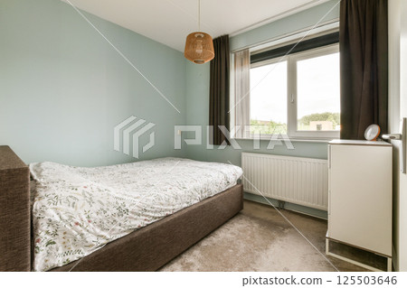 A bright and modern bedroom featuring light walls, a cozy bed, and large windows that invite natural light, creating a serene atmosphere. A bright and modern bedroom featuring light walls, a cozy bed, and large windows that invite natural light, creating a serene atmosphere. 125503646