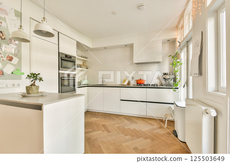 A contemporary kitchen showcasing sleek cabinetry, modern appliances, and a cozy layout that promotes a warm and inviting atmosphere for cooking. A contemporary kitchen showcasing sleek cabinetry, modern appliances, and a cozy layout that promotes a warm and inviting atmosphere for cooking. 125503649