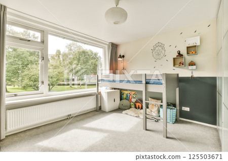 A well-lit and organized children bedroom featuring a loft bed, playful decor, and ample natural light streaming through large windows. A well-lit and organized children bedroom featuring a loft bed, playful decor, and ample natural light streaming through large windows. 125503671