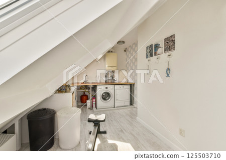 A bright and airy attic kitchen featuring modern appliances, minimalistic design, and stylish decor, creating an inviting culinary space. A bright and airy attic kitchen featuring modern appliances, minimalistic design, and stylish decor, creating an inviting culinary space. 125503710