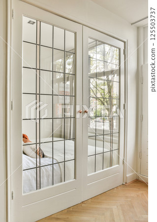 A stylish room featuring elegant glass paneled doors, showcasing a glimpse of natural light and minimalist decor that enhances the contemporary aesthetic. A stylish room featuring elegant glass paneled doors, showcasing a glimpse of natural light and minimalist decor that enhances the contemporary aesthetic. 125503737