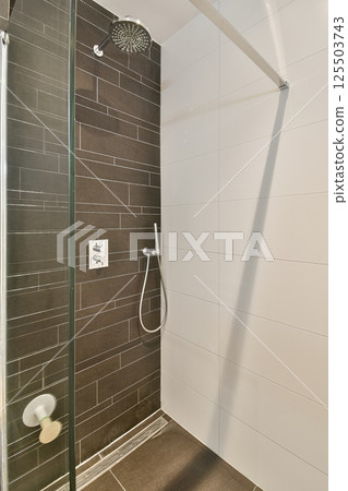 A contemporary shower space featuring dark tiles and minimalist fixtures, showcasing an elegant design for modern bathrooms. Perfect for inspiration. A contemporary shower space featuring dark tiles and minimalist fixtures, showcasing an elegant design for modern bathrooms. Perfect for inspiration. 125503743