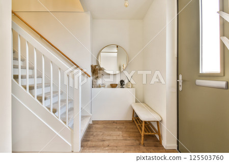 Elegant entryway showcasing a staircase, decorative elements, and minimalist furniture, creating a warm and inviting atmosphere. Elegant entryway showcasing a staircase, decorative elements, and minimalist furniture, creating a warm and inviting atmosphere. 125503760