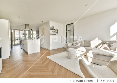 Stylish living room featuring a contemporary design, open kitchen, and ample natural light, creating a welcoming atmosphere for relaxation and entertainment. 125504005