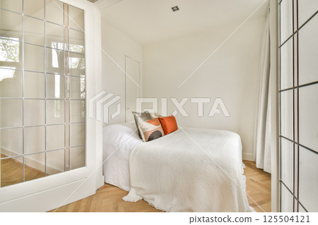 A bright and airy bedroom featuring a modern minimalist aesthetic, emphasizing soft textiles and neutral colors for a cozy atmosphere. 125504121