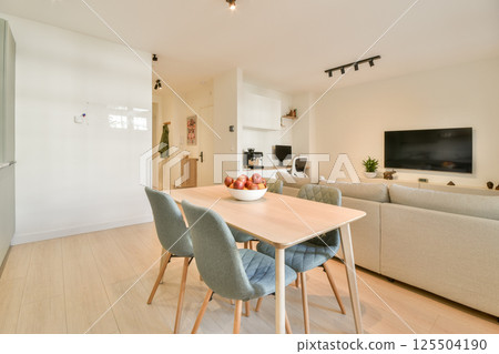 A stylish living room featuring a light color palette, contemporary furniture, and a minimalist design, perfect for relaxation and socializing. 125504190