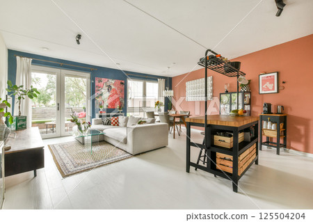 A stylish modern living room featuring vibrant wall colors, contemporary furniture, and an inviting layout perfect for relaxation and gatherings. A stylish modern living room featuring vibrant wall colors, contemporary furniture, and an inviting layout perfect for relaxation and gatherings. 125504204