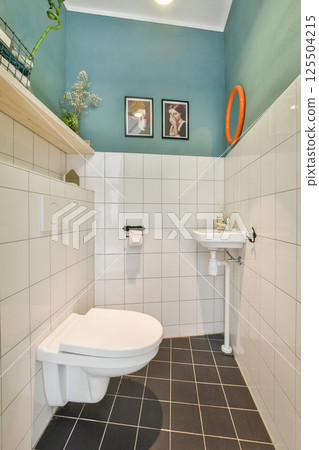 A stylish modern bathroom featuring a unique color scheme with green walls, sleek fixtures, and decorative elements adding personality to the space. 125504215