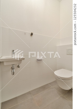 A sleek, minimalistic bathroom design featuring a wall-mounted sink and a clean toilet, emphasizing simplicity and modern aesthetics. A sleek, minimalistic bathroom design featuring a wall-mounted sink and a clean toilet, emphasizing simplicity and modern aesthetics. 125504232