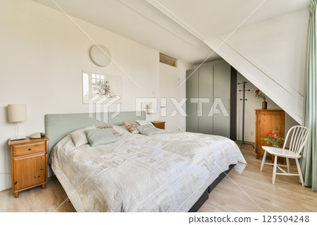 A serene and stylish modern bedroom featuring a comfortable bed, elegant decor, and minimalistic furnishings, creating a peaceful atmosphere for relaxation. A serene and stylish modern bedroom featuring a comfortable bed, elegant decor, and minimalistic furnishings, creating a peaceful atmosphere for relaxation. 125504248