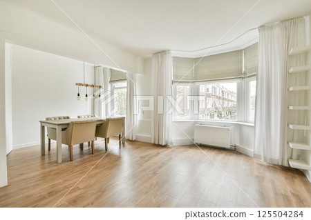 A serene dining space featuring a stylish wooden table with four chairs, large windows providing natural light, and elegant wooden flooring, showcasing a minimalist design. 125504284