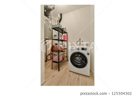 A clean and organized laundry space featuring a front-loading washer, stylish shelving for storage, and a minimalist design perfectly for modern homes. A clean and organized laundry space featuring a front-loading washer, stylish shelving for storage, and a minimalist design perfectly for modern homes. 125504302