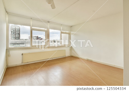 A spacious, well-lit room featuring large windows and minimal decor. The clean lines and soft colors create a tranquil atmosphere perfect for relaxation. A spacious, well-lit room featuring large windows and minimal decor. The clean lines and soft colors create a tranquil atmosphere perfect for relaxation. 125504334