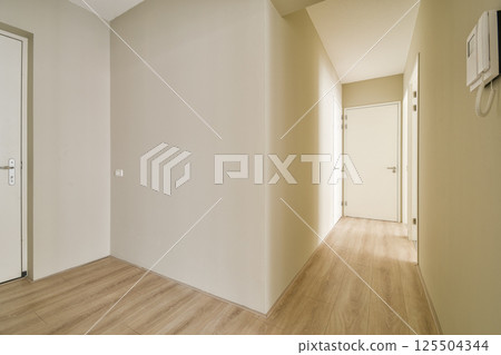 A clean, minimalist hallway featuring neutral tones and simple lines, emphasizing space and light. Ideal for modern interior aesthetics. A clean, minimalist hallway featuring neutral tones and simple lines, emphasizing space and light. Ideal for modern interior aesthetics. 125504344