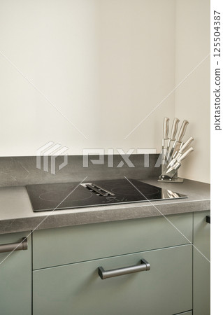 A stylish kitchen countertop showcasing sleek design, with utensils neatly arranged, exuding modern elegance and functionality for culinary enthusiasts. 125504387