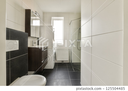 A contemporary bathroom featuring sleek fixtures, neutral colors, and a spacious layout, emphasizing minimalism and functionality. 125504485