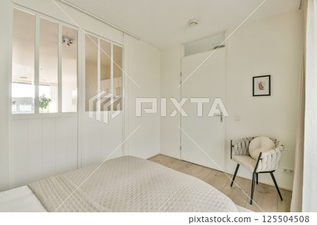 A contemporary bedroom featuring a stylish bed, soft textures, and minimalistic design elements. The space promotes tranquility and simplicity. A contemporary bedroom featuring a stylish bed, soft textures, and minimalistic design elements. The space promotes tranquility and simplicity. 125504508