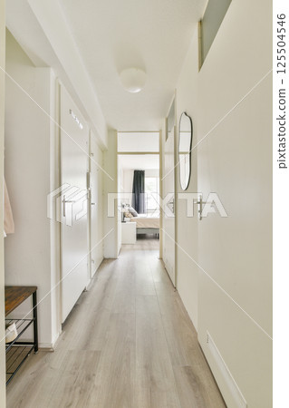 A spacious and well-lit hallway featuring modern doors, wooden flooring, and minimal decor elements, creating an inviting atmosphere for residents and guests. 125504546