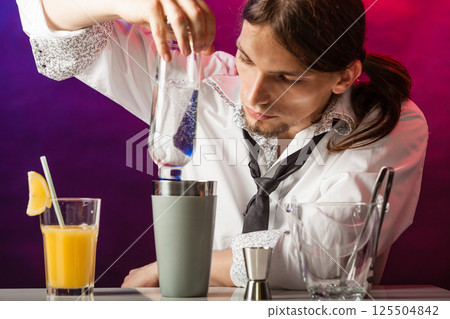 Young bartender pouring beverages. 125504842