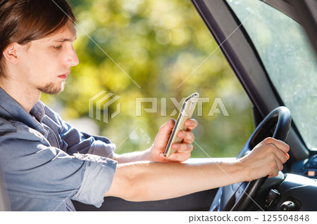 Man using his phone while driving car. Man using his phone while driving car. 125504848