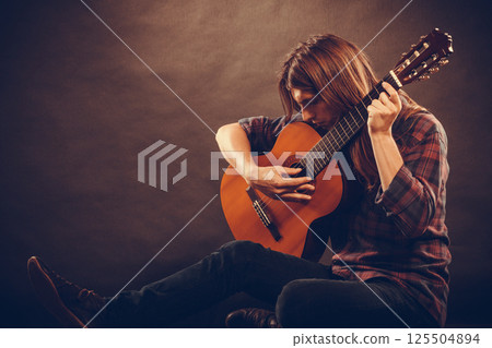 Artist with his wooden guitar. 125504894
