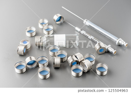 Close up view , empty glass vial, caps, with septum and syringes in chemical laboratory Close up view , empty glass vial, caps, with septum and syringes in chemical laboratory 125504963