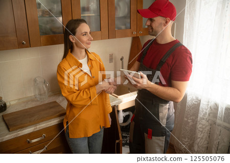 Repairman explains how to fix a sink in a kitchen setting with detailed steps and advice for homeowners Repairman explains how to fix a sink in a kitchen setting with detailed steps and advice for homeowners 125505076