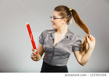 Teacher looking elegant woman holding big pencil Teacher looking elegant woman holding big pencil 125505308