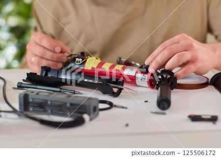 Hands of skilled workers diligently engaged in the intricate repair of mechanical devices 125506172