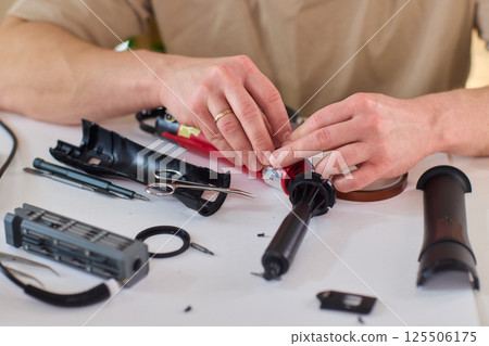 Hands of skilled workers diligently engaged in the intricate repair of mechanical devices 125506175