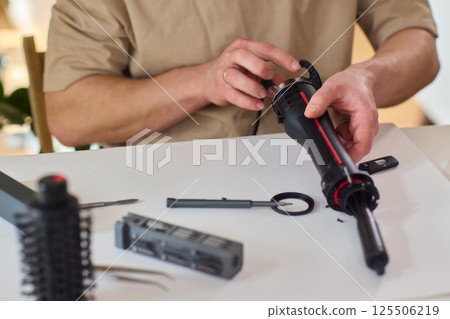 Hands of skilled workers diligently engaged in the intricate repair of mechanical devices 125506219