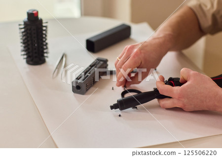 Hands of skilled workers diligently engaged in the intricate repair of mechanical devices 125506220