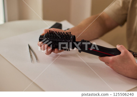 Hands of skilled workers diligently engaged in the intricate repair of mechanical devices 125506240