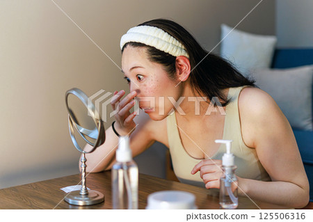 Middle-aged woman concerned about facial blemishes 125506316