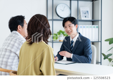 Middle-aged couple consulting with a planner Middle-aged couple consulting with a planner 125506523