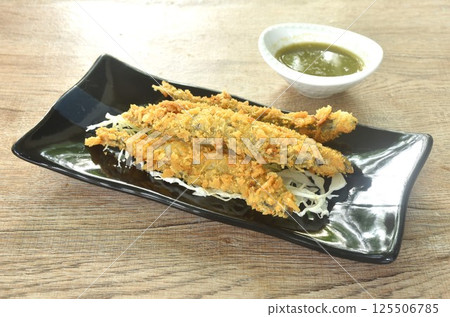 deep fried capelin fish or Shishamo Japanese food with chop cabbage on plate dipping spicy seafood sauce 125506785