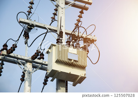 Large high-voltage transformers mounted on poles 125507028