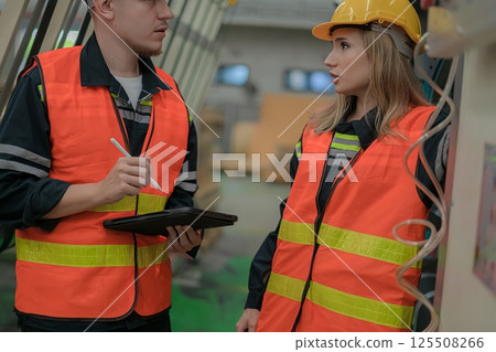 Two construction workers discuss safety protocols on a job site, showcasing teamwork and professionalism. Two construction workers discuss safety protocols on a job site, showcasing teamwork and professionalism. 125508266