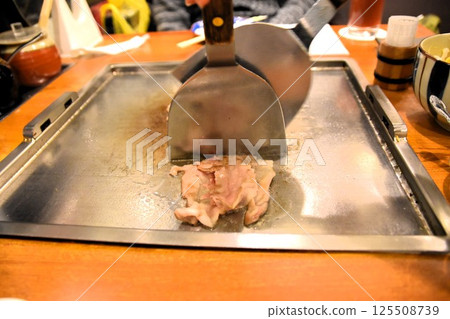A man preparing okonomiyaki 125508739