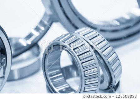 Close up scene the tapered rolling bearing parts in the light blue scene. Close up scene the tapered rolling bearing parts in the light blue scene. 125508858